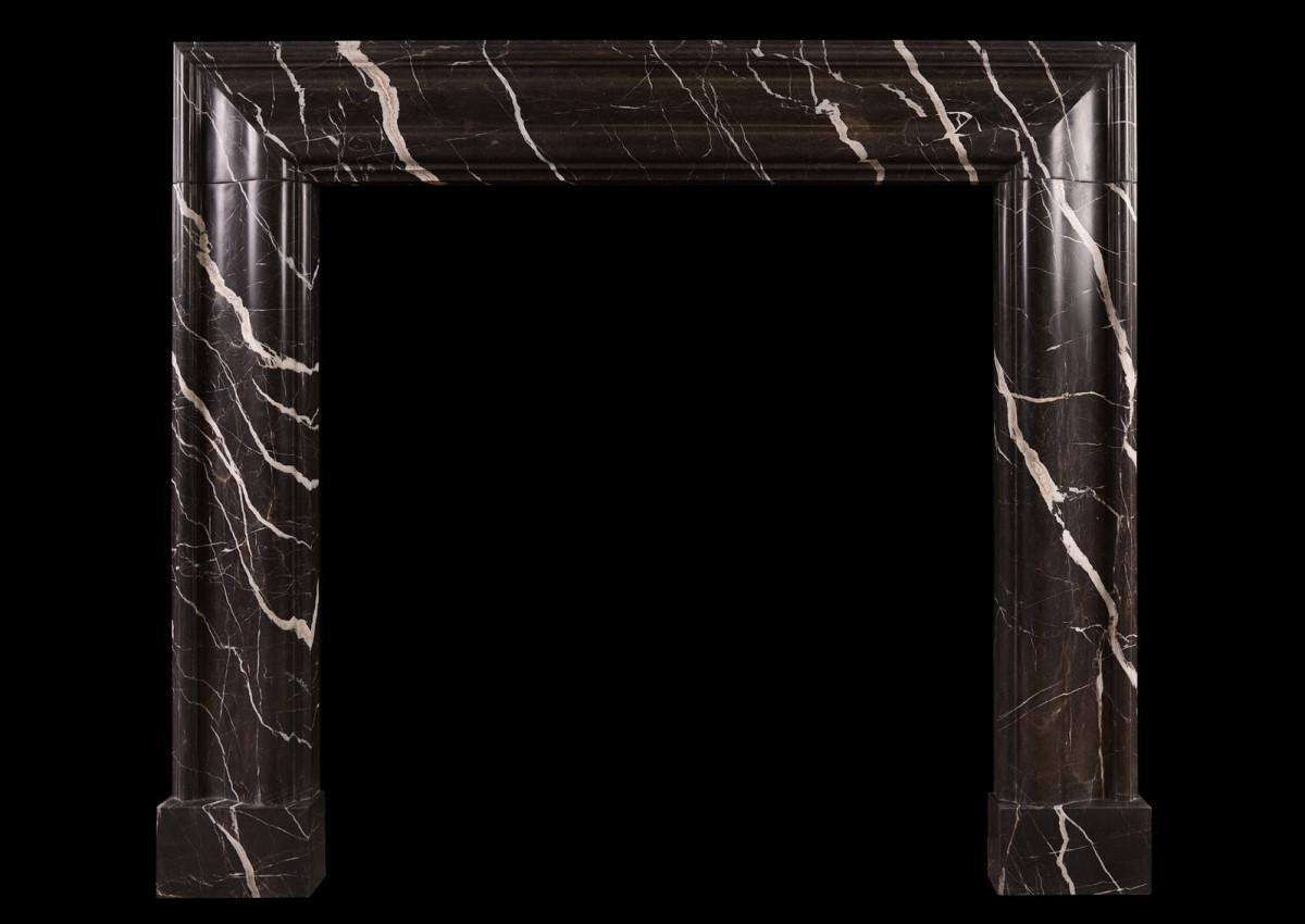 A brown marble bolection fireplace